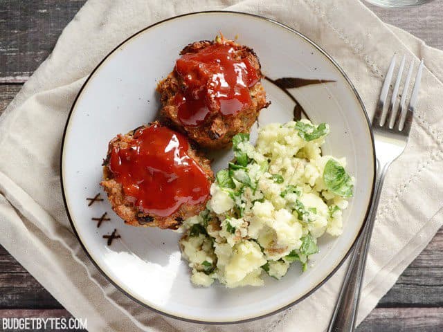 Plate with two Mini Garden Turkey Loaves and a side of potatoes, fork on the side 