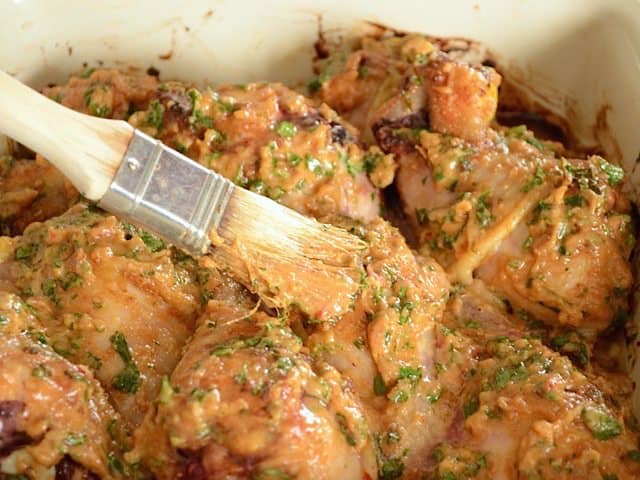 Extra sauce being brushed onto chicken 