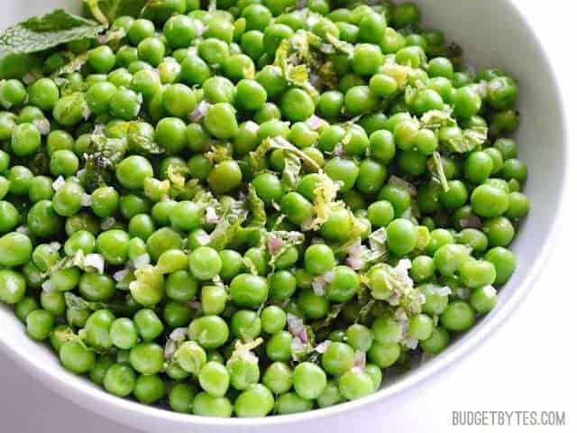 A close-up of minty pea salad in a bowl.