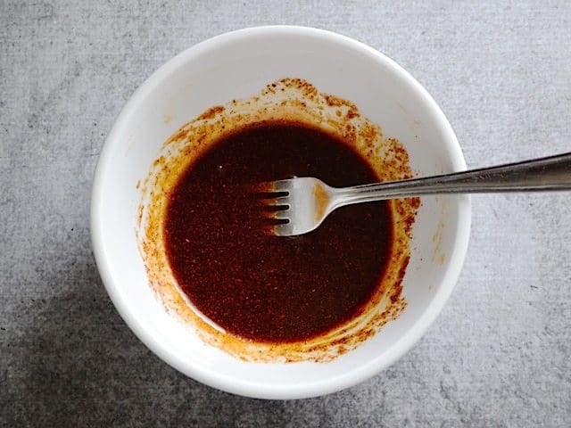 Oil and Honey added to spices in mixing bowl and. stirred together with fork 