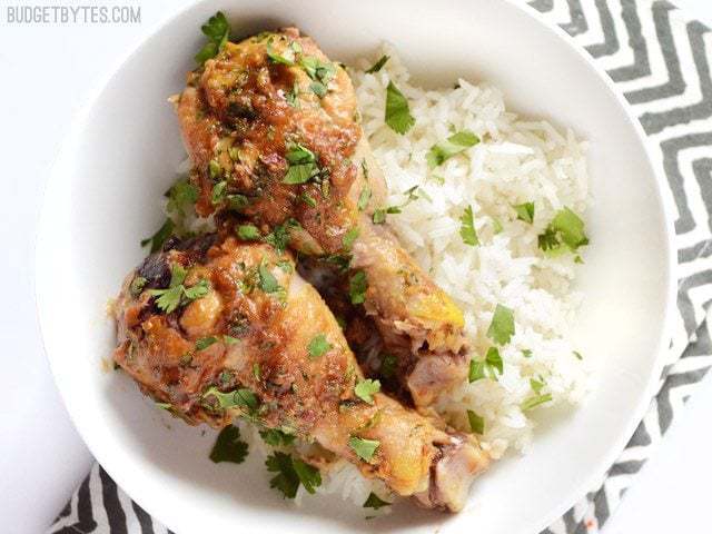 A bowl of Thai peanut chicken garnished with herbs.