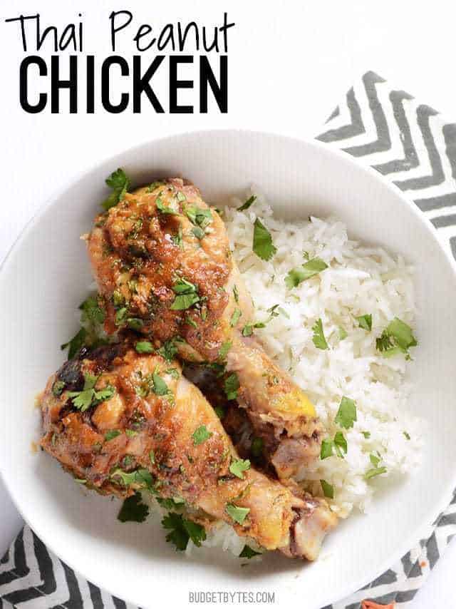 Top view of a plate of Thai Peanut Chicken with a side of rice, plate sitting on a white and gray chevron napkin 