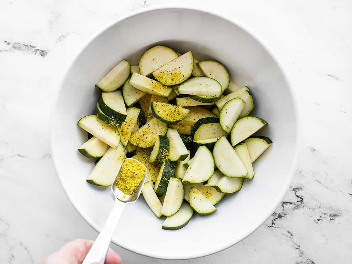 lemon pepper being sprinkled over the zucchini