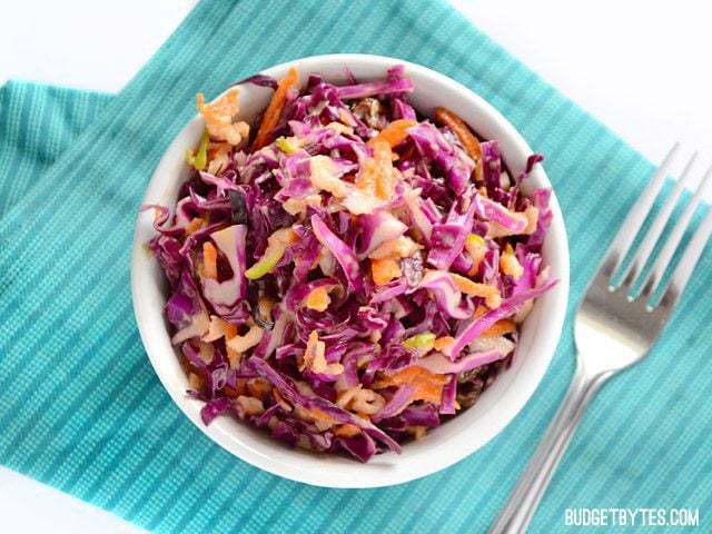 A bowl of apple cabbage slaw with fresh ingredients.