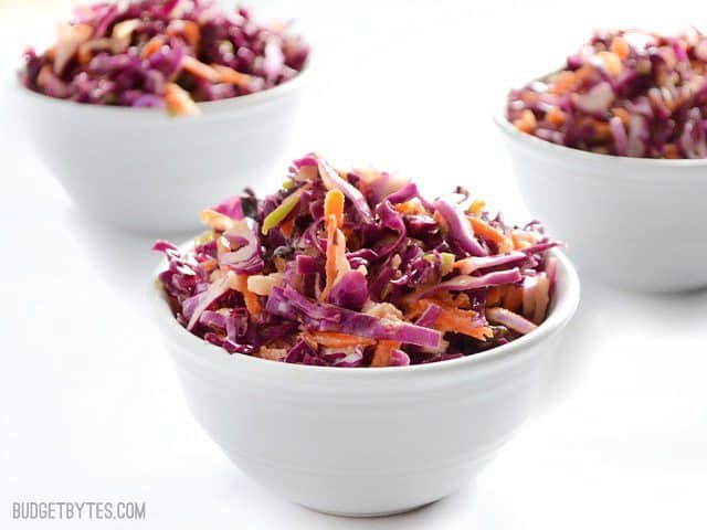 Three small bowls of Apple Cabbage Slaw viewed from the side