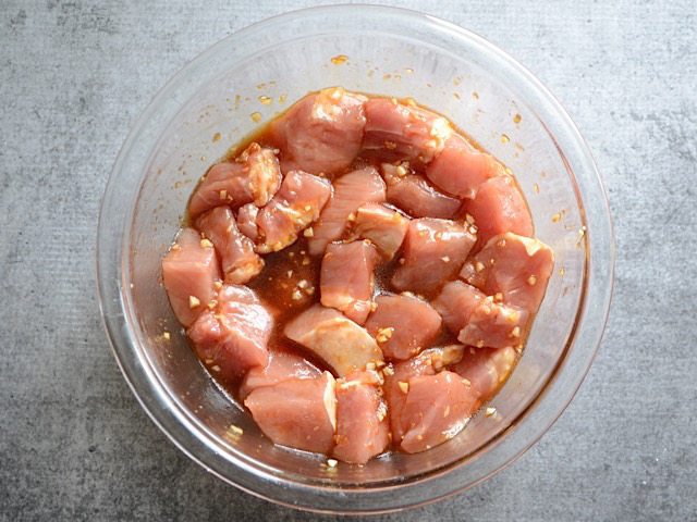 Pork marinating in a glass bowl