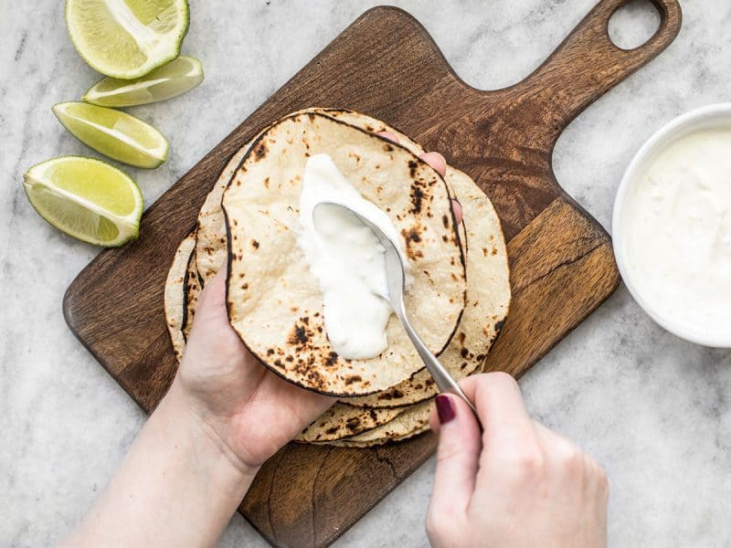 Spread lime crema on tortillas