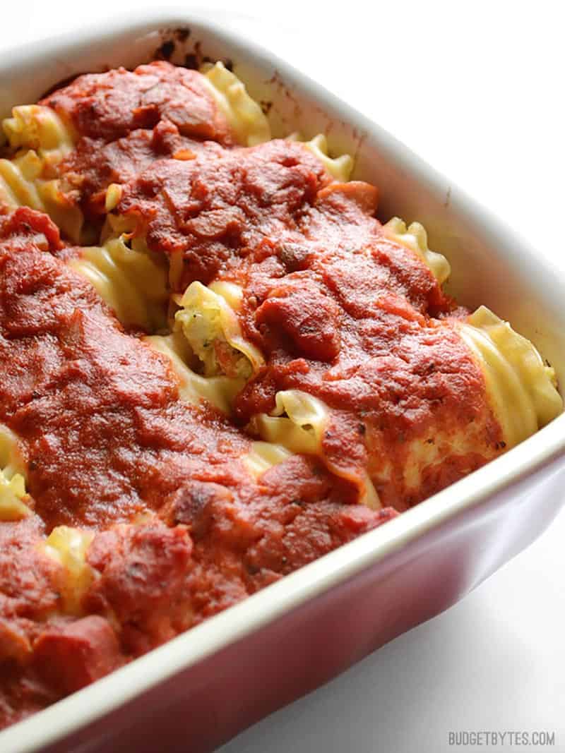 Side view of the casserole dish full of vegetable lasagna roll ups