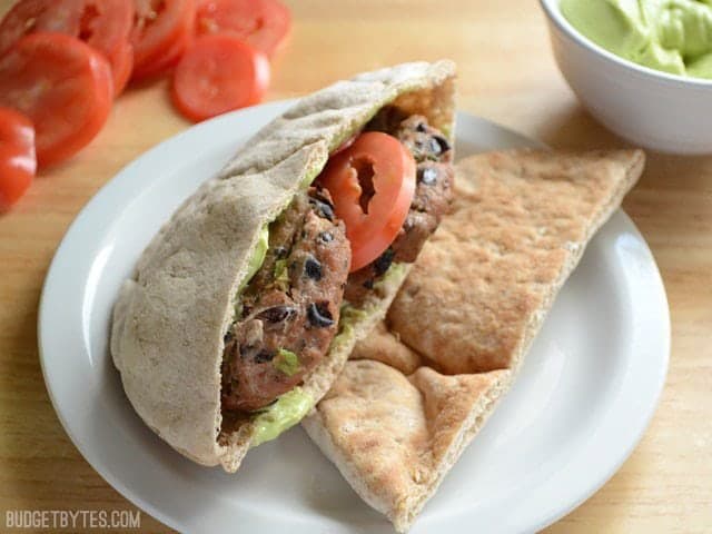 Mini Black Bean Turkey Burgers stuffed into a pita with tomato and avocado sauce