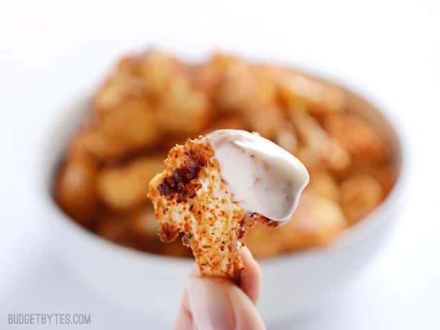 Close up of one cauliflower floret dipped in ranch. 