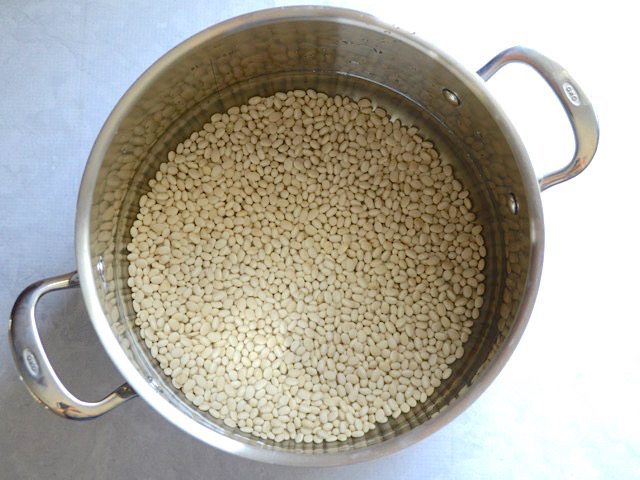 White beans soaking in a pot full of water