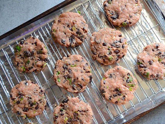 Shaped turkey burger patties on a baking sheet fitted with wire cooling racks