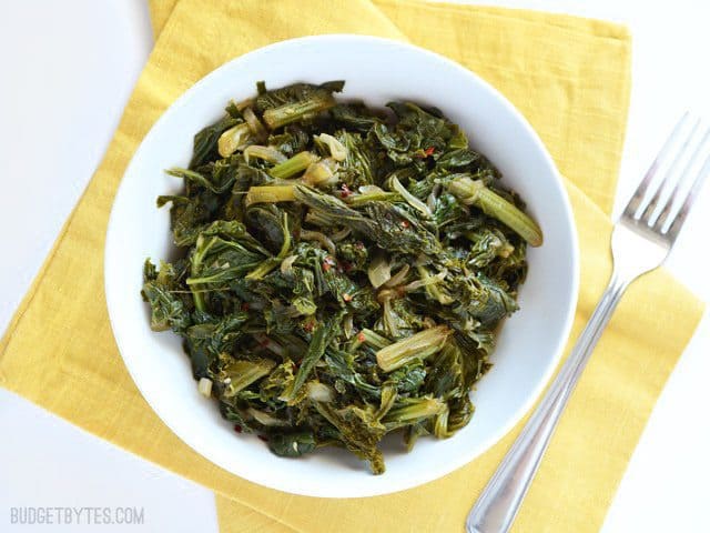 Overhead view of a bowl of Vegetarian Mustard Greens on a yellow napkin