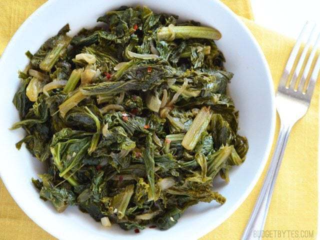 A close-up of cooked vegetarian mustard greens in a bowl.