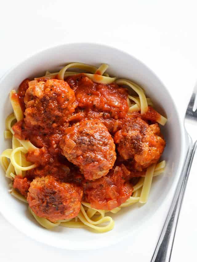 Overhead view of a bowl of pasta with meatballs and marinara