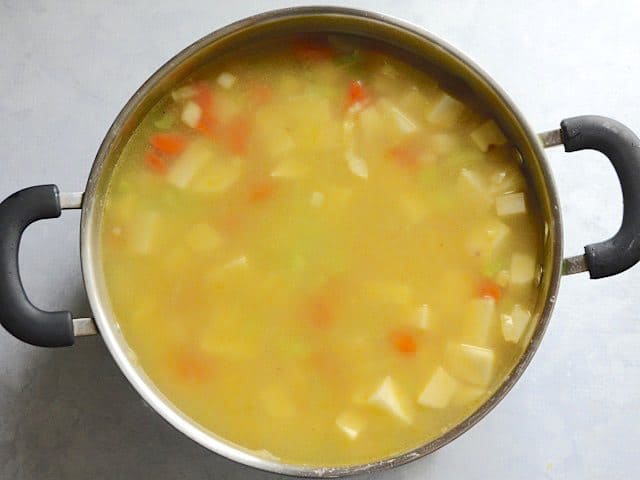 Chicken broth added to the pot