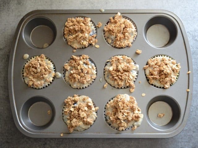 Muffin tin filled with batter and topped with crumble