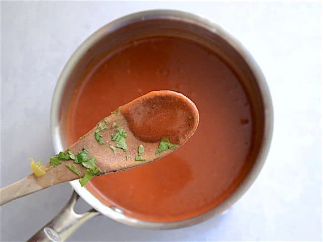 Thickened Enchilada Sauce on a wooden spoon