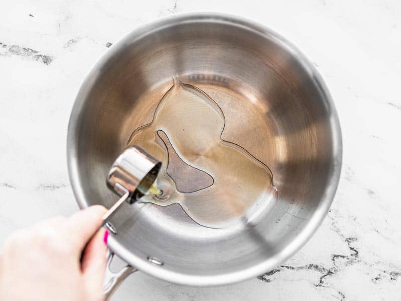 Oil being poured into a sauce pot