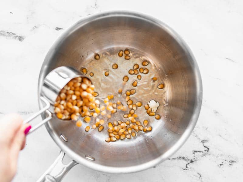 Add the rest of the popcorn kernels to the hot oil.