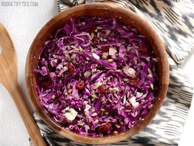 Overhead view of cranberry and cabbage salad in a bowl on a striped napkin