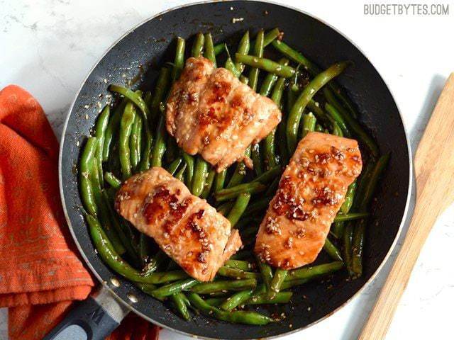 Sesame Glazed Salmon and Green Beans in the skillet, orange napkin on the side