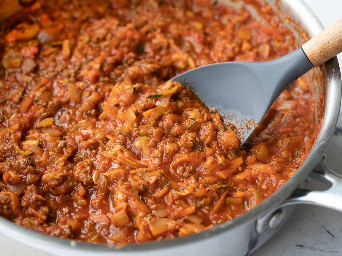 Side view of hidden vegetable pasta sauce in a skillet with a spatula