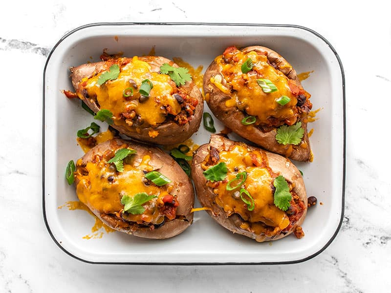 Turkey chili smothered sweet potatoes with melted cheese and topped with cilantro