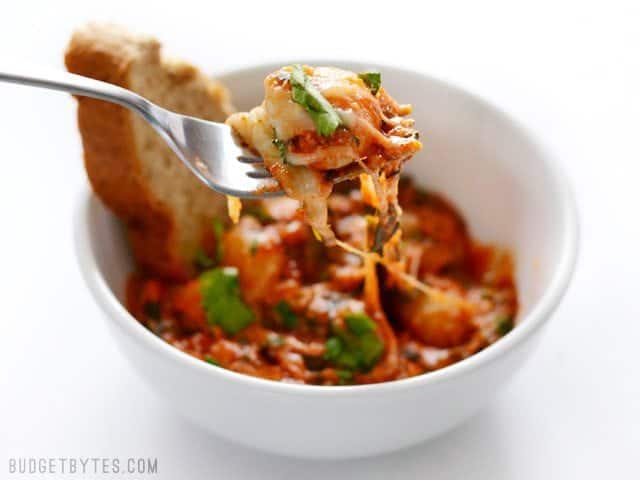 A forkful of Cheesy Gnocchi Skillet with the bowl in the background