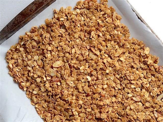 unbaked granola spread on a parchment lined baking sheet