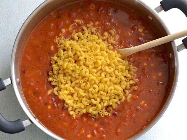 Uncooked macaroni added to the pot