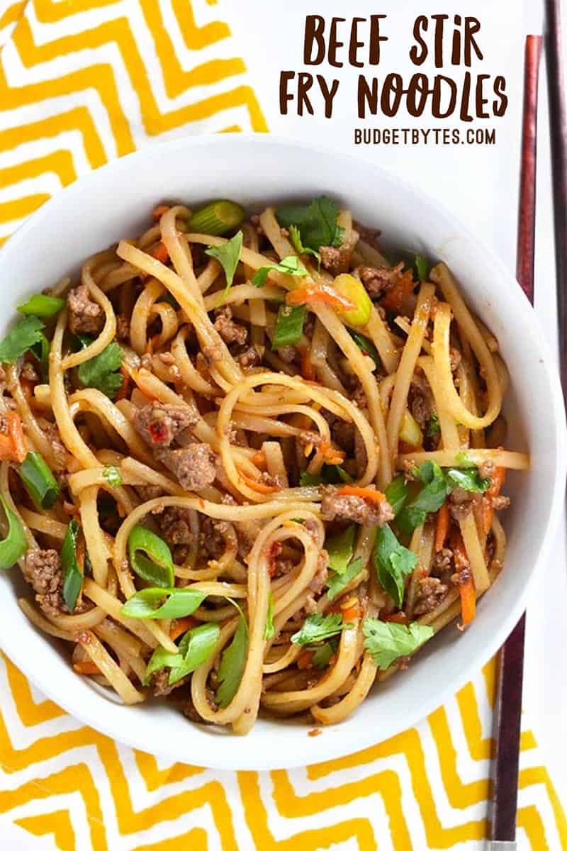 Overhead view of a bowl full of beef stir fry noodles, title text in the top corner