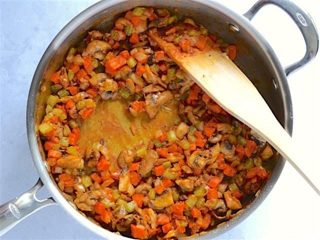 Flour and tomato paste added to the vegetables in the skillet