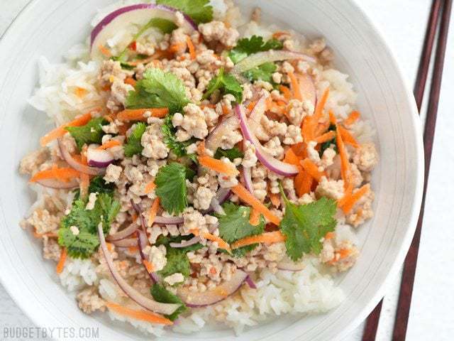 Finished Nam Sod (Thai Pork Salad) in a bowl with rice and chopsticks on the side