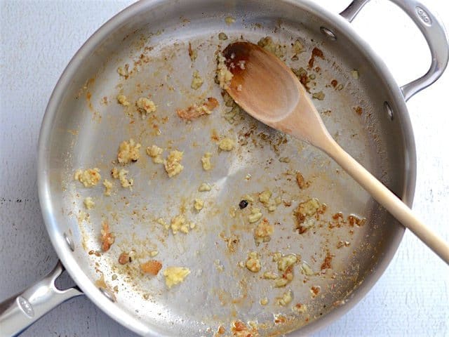 Sautéed Garlic in the skillet with a wooden spoon