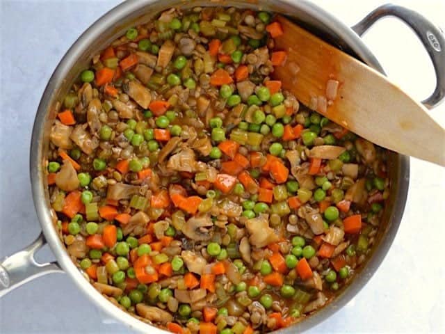 Lentils and peas added to vegetables and gravy in the skillet