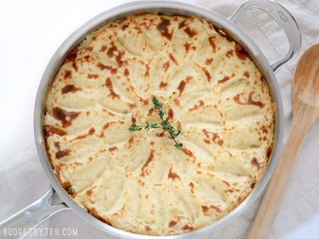 Baked Skillet full of Vegetarian Shepherd's Pie, wooden spoon on the side