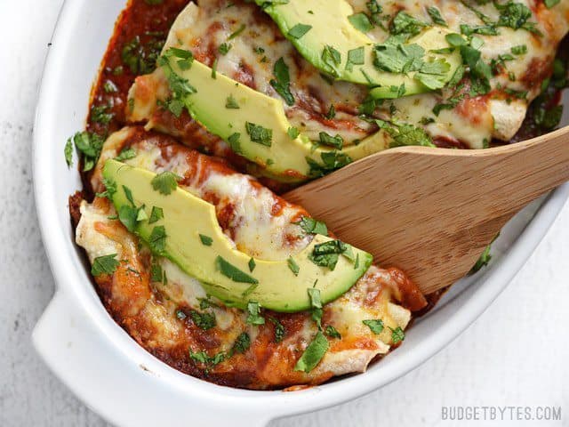 Weeknight enchiladas served with a scoop.