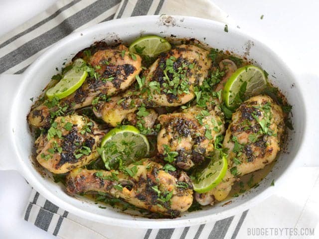 Cilantro Lime Chicken Drumsticks topped with fresh cilantro and sliced limes