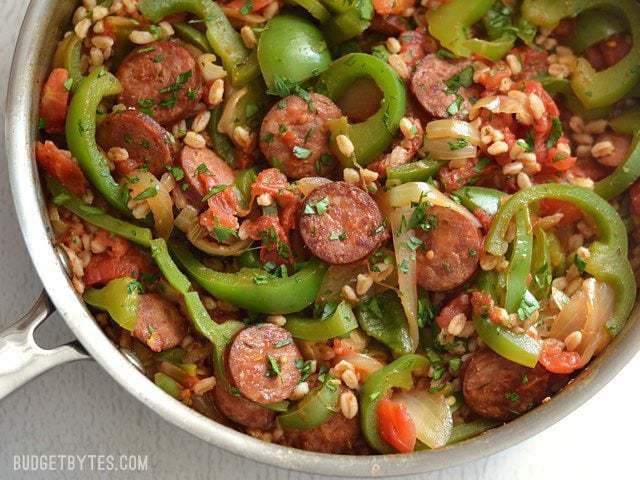 Smoked sausage, peppers, and farro in a skillet.