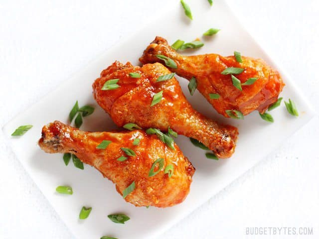 Crispy baked honey Sriracha chicken drumsticks.