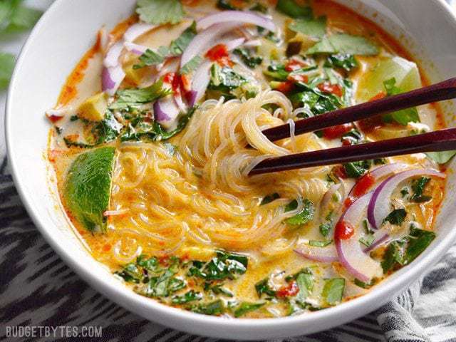 Close-up of Thai curry vegetable soup with noodles.