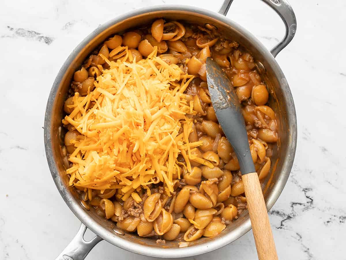 Shredded cheddar added to the skillet