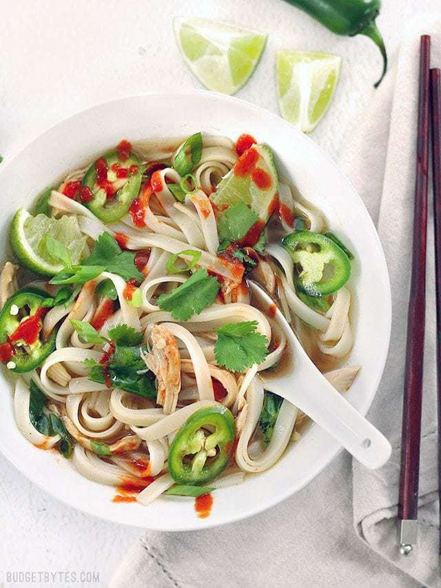 Overhead view of a big bowl full of Quickie Faux Phở seasoned with a drizzle of sriracha