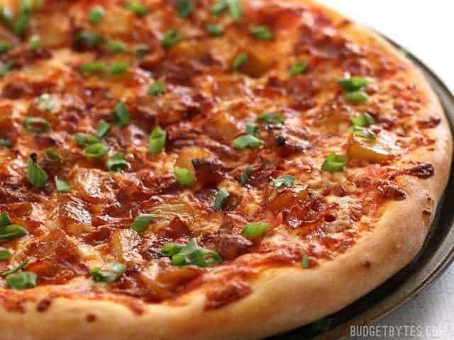 Bacon and caramelized onion pizza on a plate.