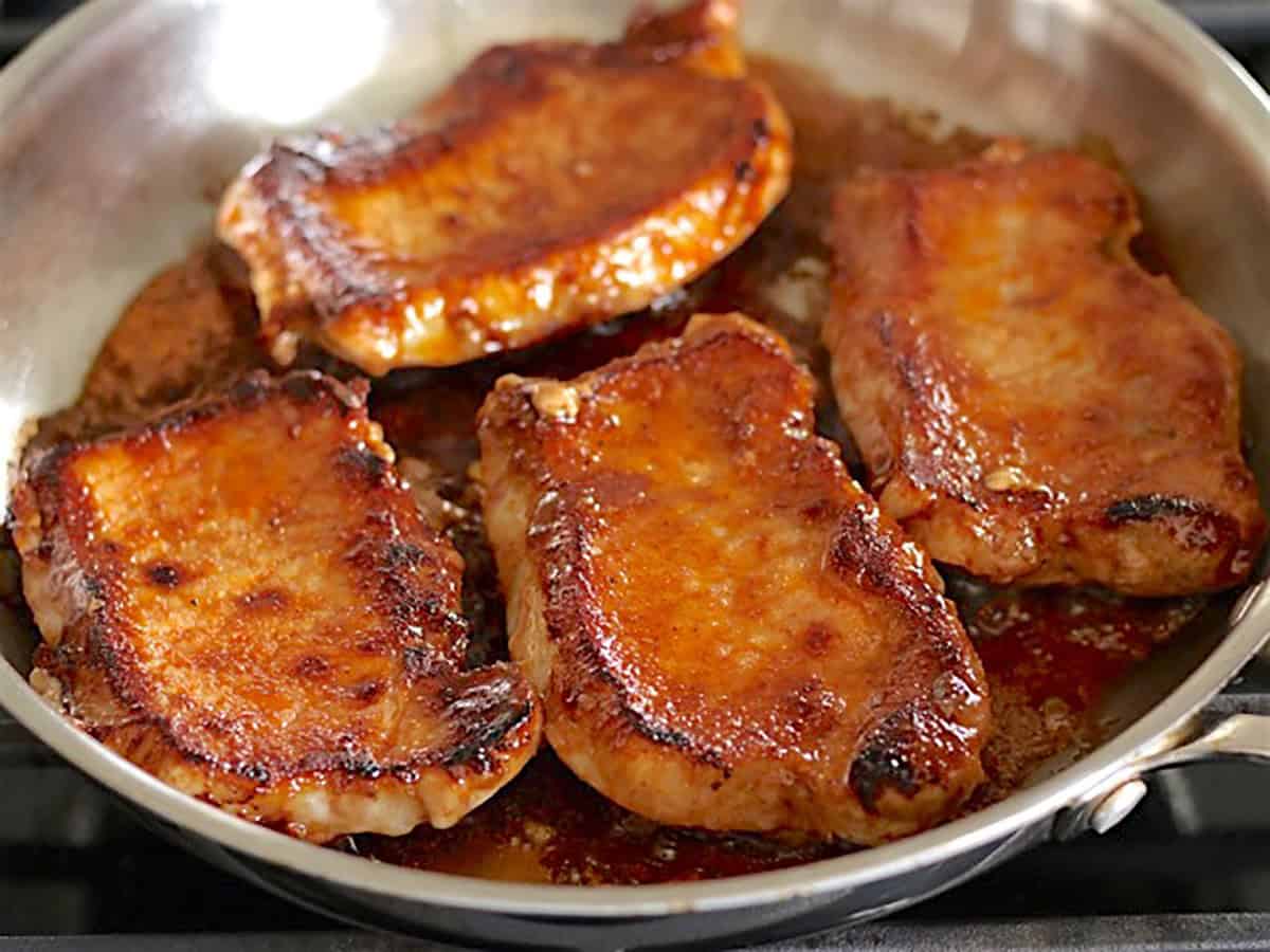 Seared pork chops in the skillet.