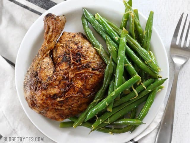 Overhead view of a plate full of Lemon Butter Green Beans and roasted chicken