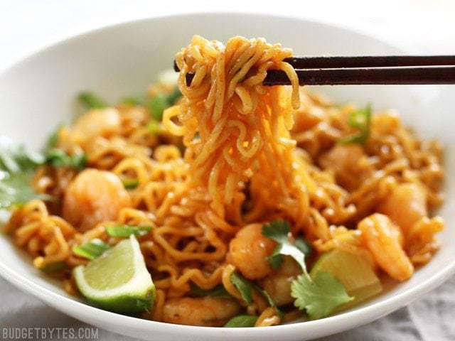 Chopsticks picking up a clump of Lime Shrimp Dragon Noodles out of the bowl