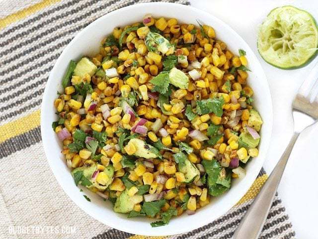 Warm corn and avocado salad served in a bowl.