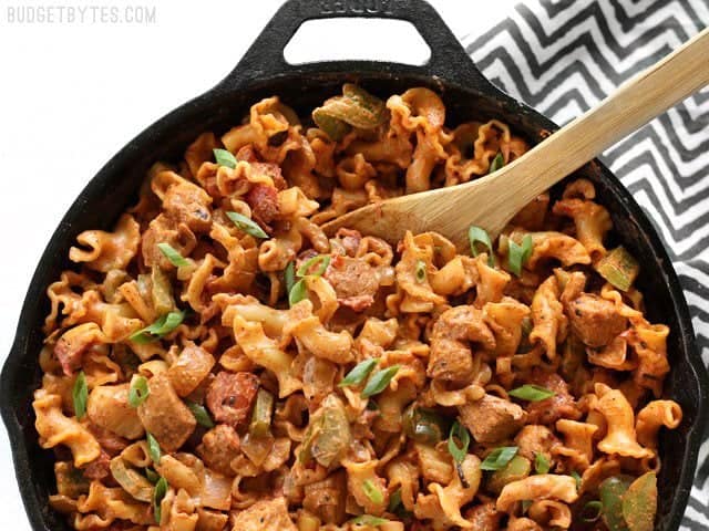 Overhead view of a skillet full of Creamy Chicken Fajita Pasta with a wooden spoon in the top